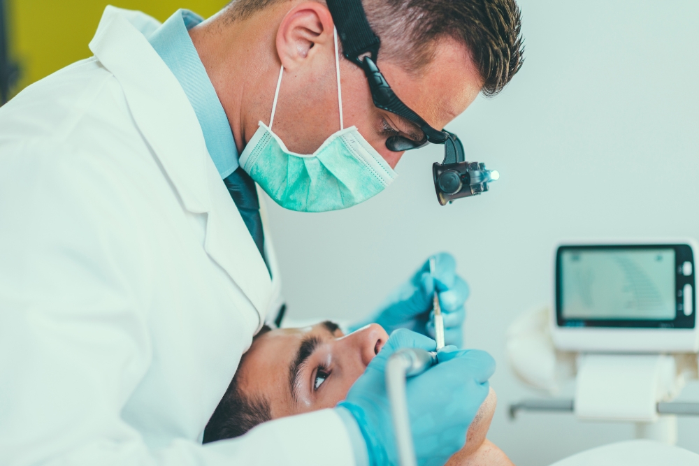 Dentist performing a root canal procedure, showing the meticulous dental work involved in determining how long a root canal lasts.