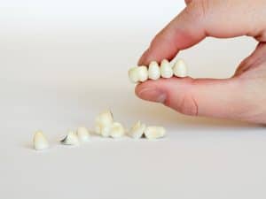 a person holding a damaged dental crown in his hand