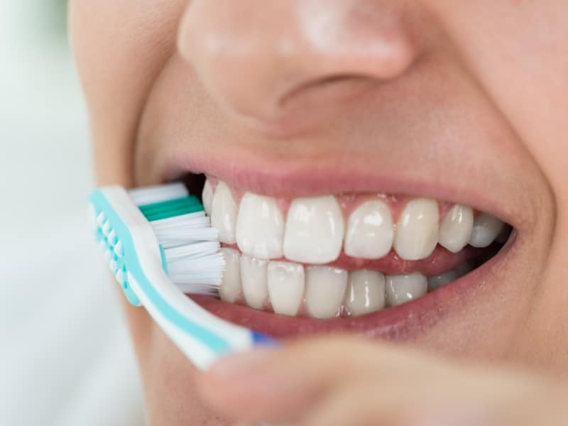 Close-up of someone brushing their teeth to prevent gum recession. Good oral hygiene.